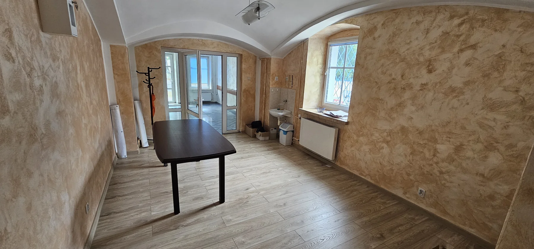 Drugie pomieszczenie lokalu z nową jasną podłogą i przeszklonym przepierzeniem